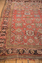 Antique Kurdish Bijar rug's aged edge, featuring geometric Mina Khani vinery in red and brown tones.