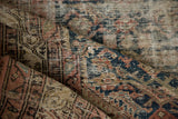 Distressed vintage Malayer rug with textured pile, showing worn areas, blue, and dusty rose.