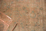 Vintage Kashan carpet detail with time-softened beige texture, mint green and peach pattern.