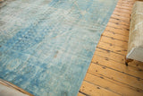 Worn corner of a vintage distressed Mahal fragment, highlighting faded powder blue and sand tones.