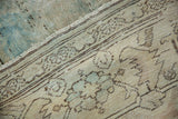 Distressed vintage Mahal carpet detail showing pale blue abrash, exposed foundation, and patterned sand border.
