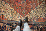 Antique Farahan Sarouk carpet with intricate floral motifs, oversized finial, and wide navy border featuring pawn detail.