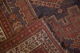 Antique Afshar rug's red and blue geometric hook and latch motifs, tattered edge, worn pile.