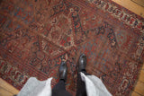 Antique Qashqai tribal rug with pictorial animals, exposed foundation, and muted tones.