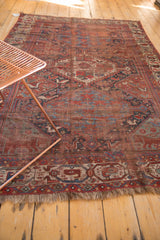 Hand-knotted antique Qashqai rug corner detail, revealing wear to knot heads and tribal motifs.