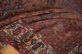Hand-knotted texture with raspberry, navy, and ivory geometric motifs on antique Qashqai rug.