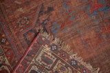 Antique Qashqai rug showing storied pile, detailed geometric border, and natural fringe.