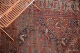 Close detail of antique Qashqai rug field, revealing stylized birds, deep reds, blues, and foundation wear.
