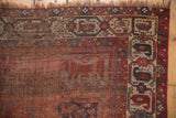 Antique Qashqai rug's rust red field displaying abstract bird motifs and visible foundation weave.