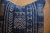 Indigo blue pillow with mudcloth style geometric print and textured jute piping.