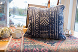 Indigo mudcloth throw pillow corner with distinctive jute and linen piping detail.