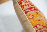 Antique rug fragment throw pillow: textured red, gold, beige pile and plain fabric backing.