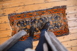 Worn cobalt blue field and tattered tangerine orange border of vintage Chinese runner.