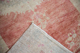 Folded corner of the distressed Oushak rug showing its hand-knotted foundation.