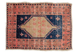 Vintage distressed Oushak rug, dusty blush border, navy field, beige diamond medallion. 2'3