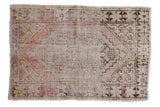 Distressed vintage Oushak rug, faded diamond medallion and geometric floral borders in soft hues.