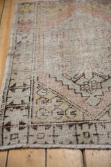 Distressed vintage Oushak rug corner with geometric germinating pod spandrel and side selvage.