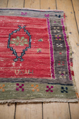 Distressed Oushak rug texture: cherry red field with worn pile, floral medallion, and patterned borders.