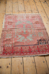 Distressed Oushak rug showing faded blush and silver quatrefoil plant motifs.