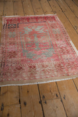 Distressed vintage Oushak rug, showing worn pile, blush, silver, and original selvage.