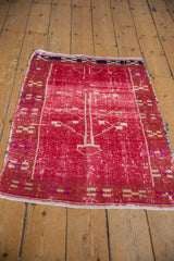Faded cherry red pile, distressed texture, and geometric tree of life motif.