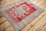 Distressed Oushak square rug with asymmetric floral bouquet in blush and cherry red.
