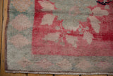 Distressed vintage Oushak rug corner showing even pile wear, silver-blue border.