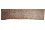 Distressed Oushak runner with pale tangerine orange field, sky blue medallions, and mostly even wear.