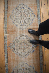 Vintage distressed Oushak rug runner featuring a pale orange medallion underfoot.