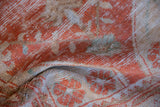 Distressed Oushak rug close-up: worn pile, visible foundation, pale brick red and ivory motifs.