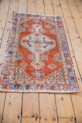 Distressed madder root red field with geometric pale royal blue border on a vintage Oushak rug.