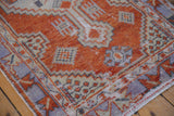 Distressed Oushak rug corner with geometric germinating floral patterns in madder red and ivory.