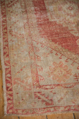 Distressed Oushak rug with dusty raspberry red pile, mostly even wear, and serrated border.