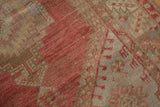 Distressed vintage Oushak detail, dusty raspberry red and sand serrated patterns, with foundation showing.
