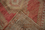 Distressed Oushak rug corner showing raspberry red pile, hand-knotted foundation, and selvage.