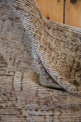 Close-up of distressed Oushak rug, highlighting worn texture and soft beige-brown tones.