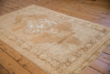 Distressed vintage Oushak rug corner, abrashed bronze field, geometric vinery, subtle patina.