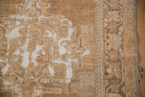 Distressed Oushak rug with bronze-coffee pile wear revealing ivory foundation.