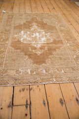 Short, textured fringe and geometric beige border on a distressed vintage Oushak rug.