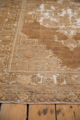 Vintage distressed Oushak rug corner with bronze and beige geometric vinery, showing wear.