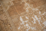 Distressed Oushak rug showing worn pile, exposed foundation, and faded geometric design.