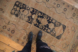 Vintage Oushak rug's navy blue elongated medallion, featuring finned plants and starburst motifs.