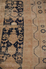 Detail of vintage Oushak rug: navy geometric motifs, starbursts, and worn beige field.