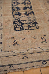 Vintage Oushak rug, navy geometric motifs on beige field with foundation showing through.