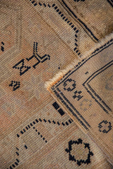 Worn beige pile, exposed foundation, and intact selvage on a vintage Oushak rug.