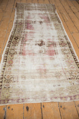 Distressed texture of a vintage Oushak runner, with faded purple tones and geometric border.
