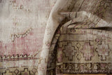 Textured distressed Oushak rug runner showing worn pile, geometric motifs, and faded purple.
