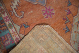 Distressed tangerine orange Oushak rug pile with visible wear and hand knotted reverse.