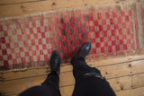 Vintage distressed Oushak runner showcasing checkered cherry red, beige, and dark brown tones.