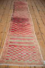 Distressed vintage Oushak runner with cherry red, beige checkered field and floral minor border.